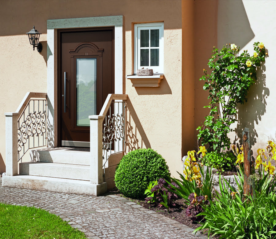 Dunkle Holz-Haustür mit Treppenaufgang, grüner Eingangsbereich, modernes Wohnhaus