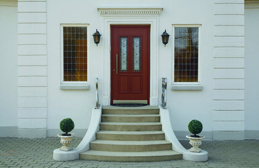 Eingang mit roter Haustür, klassische Architektur, Treppenaufgang mit Pflanzendeko