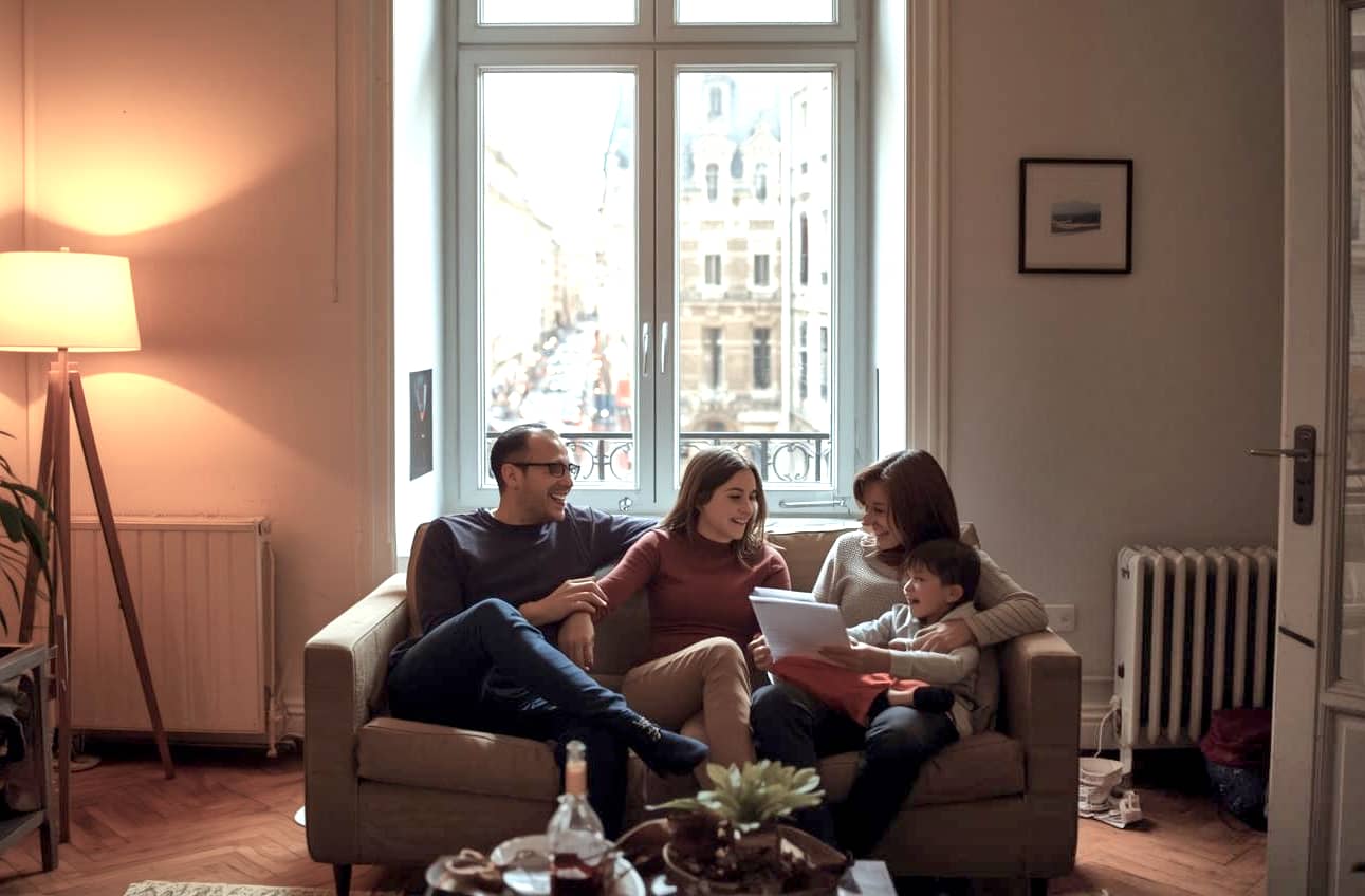 Eine Familie kann entspannt miteinander plaudern. Und das obwohl der Verkehrslärm draußen enorm ist. Das ist die beste Art, Lärmschutz zu erklären - mit Wohnkomfort!